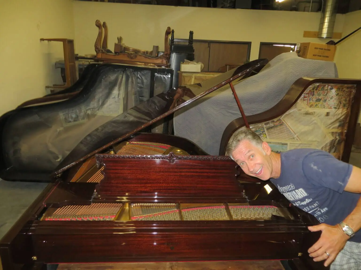 A man is working on an old piano.