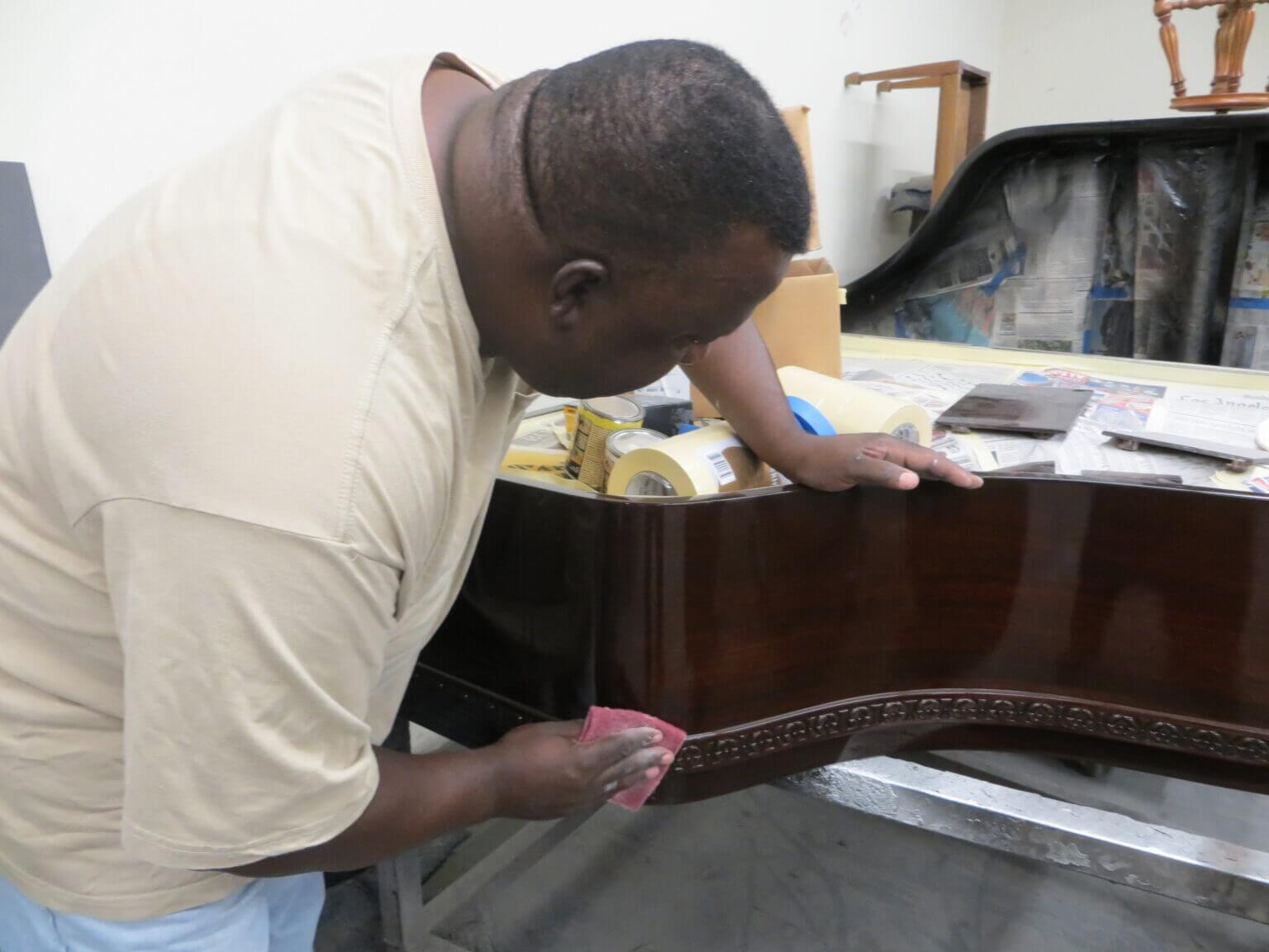 A man is working on a piano