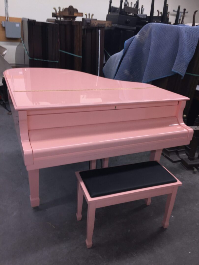 A pink piano sitting on top of a floor.