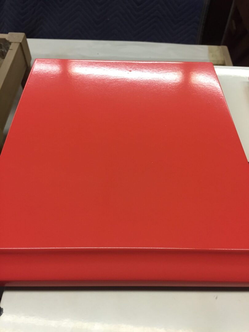 A red sheet of plastic is sitting on top of cardboard.