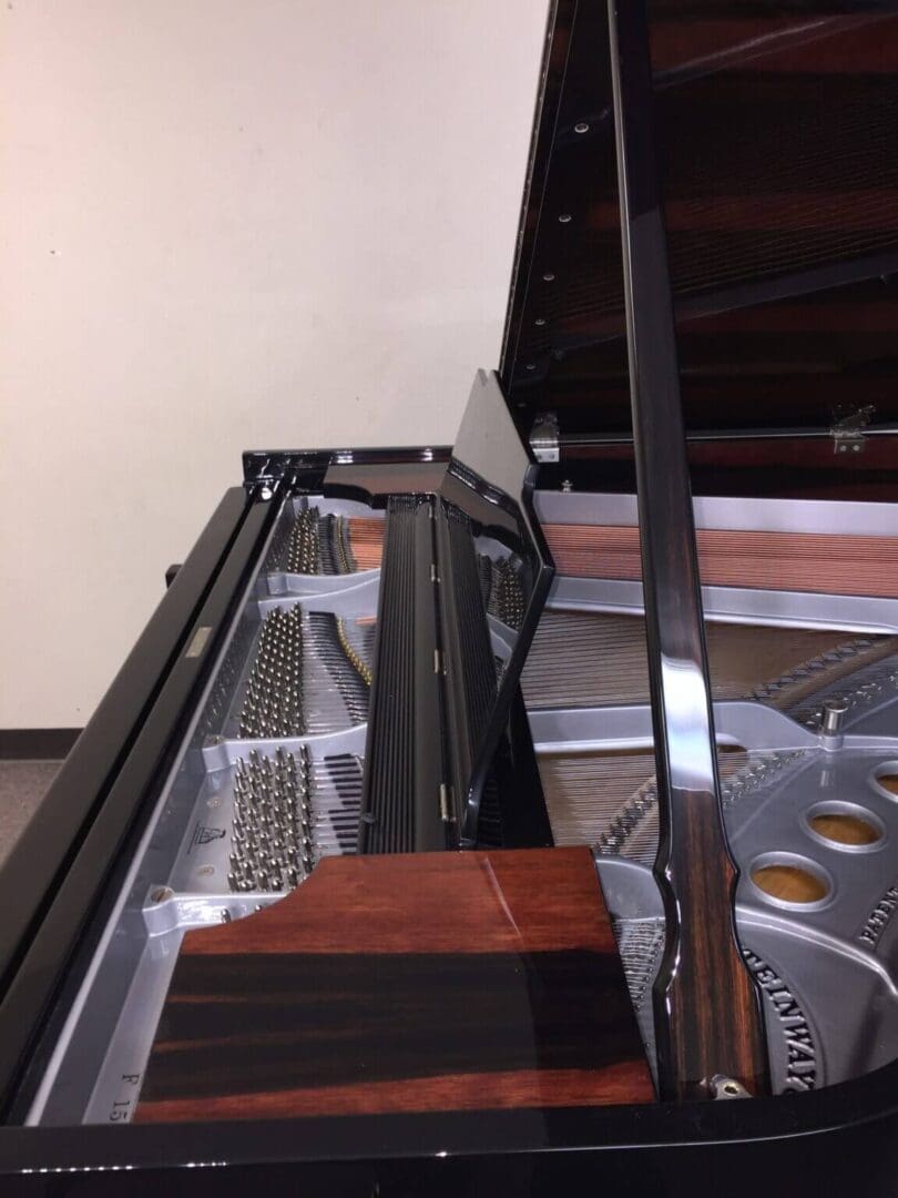 A piano with its keyboard removed and the bottom of it.