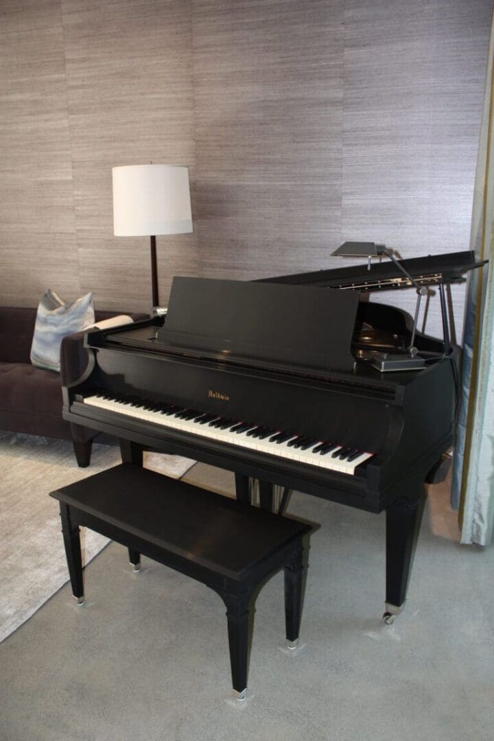 A black piano sitting in the middle of a room.