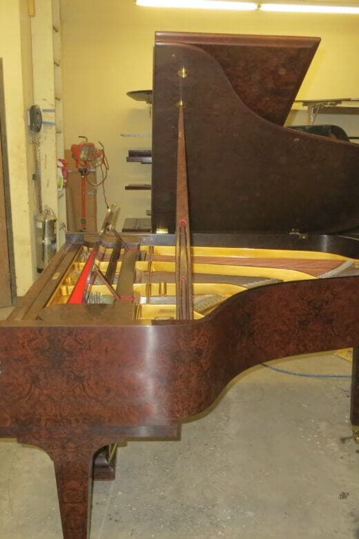 A piano is being worked on in the shop.