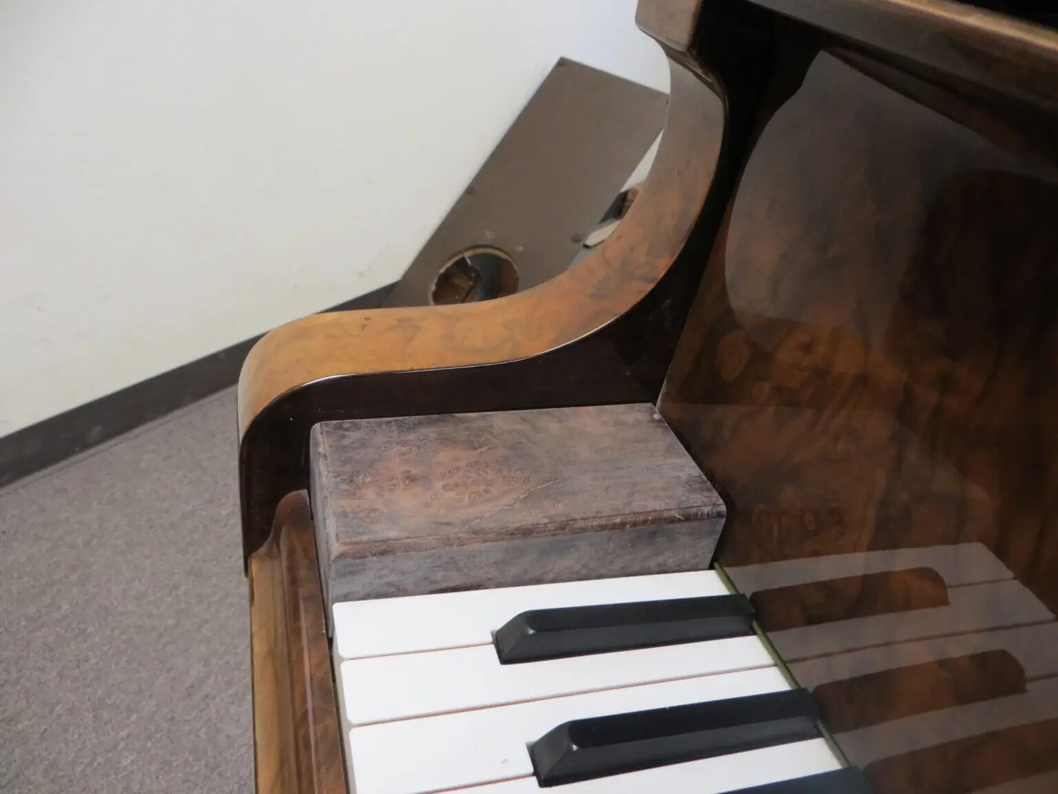 A piano with a wooden case on top of it.