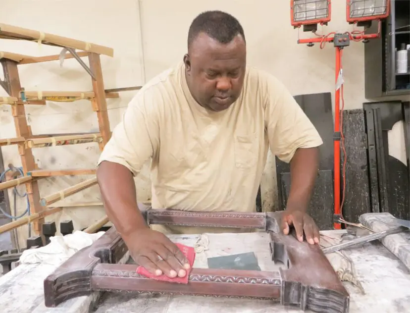 A man working on a wooden frame in a room.